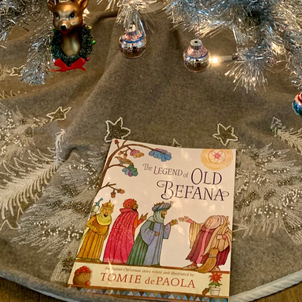 The Legend of Old Befana by Tomie dePaola under white christmas tree